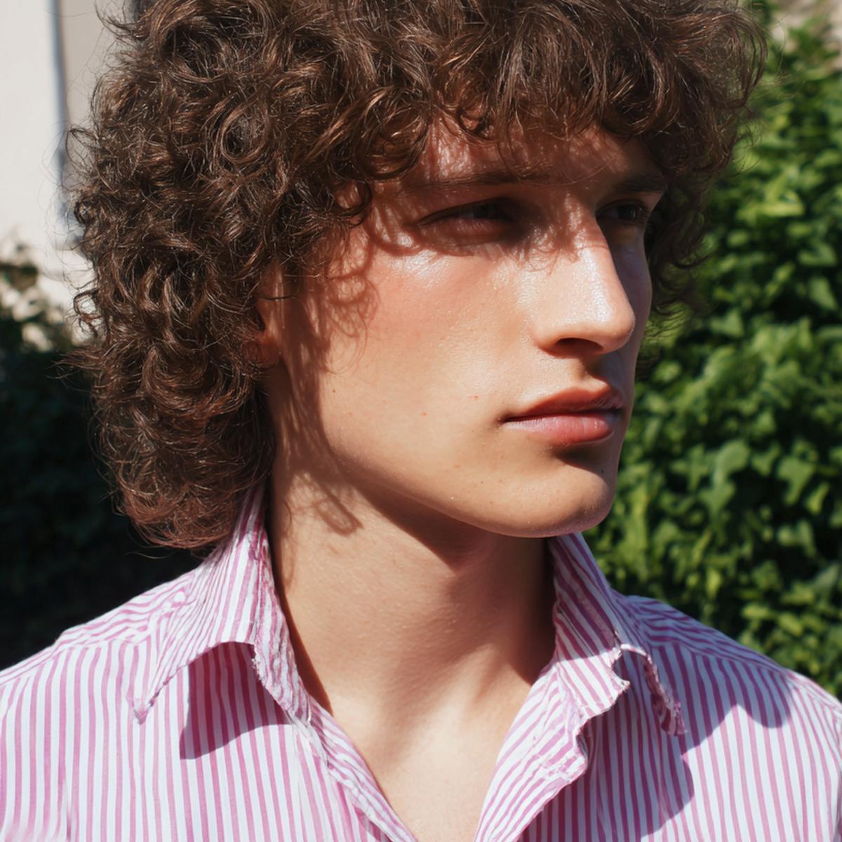 24. Coupe mi-longue masculine avec Cheveux bouclés frange homme et raie souple